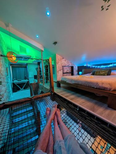 une personne allongée sur le sol dans une pièce avec deux lits dans l'établissement Maison Insolite avec Spa Privatif, à Monbalen