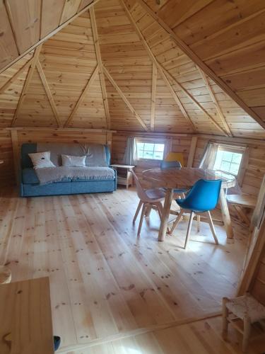 une chambre avec une table et des chaises dans une petite maison dans l'établissement Kota au Mont des Autruches, à Sainte-Sigolène
