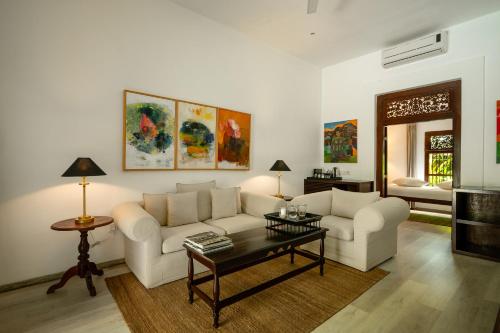 a living room with two white couches and a table at Nyne Hotels Rock Villa - Bentota in Bentota