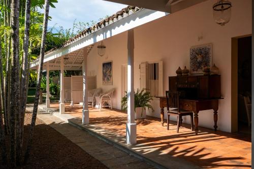 an outdoor patio with a piano and a table at Nyne Hotels Rock Villa - Bentota in Bentota