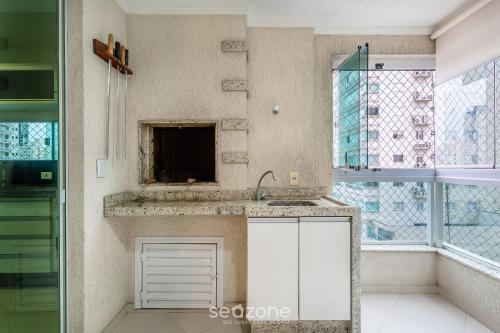 a kitchen with a sink and a window at Hospede-se a passos do mar em Meia Praia - VIM in Meia Praia