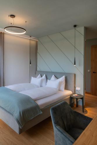 a bedroom with a large bed and a chair at steiRerBLiCke - Domaine Sernau Muscat in Gamlitz