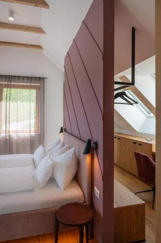 a room with a bed and a window and a table at steiRerBLiCke - Domaine Sernau Muscat in Gamlitz