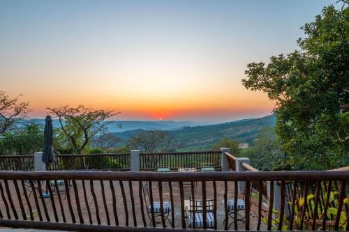 a view from a deck with a sunset in the background at Chestnut Country Lodge in Hazyview