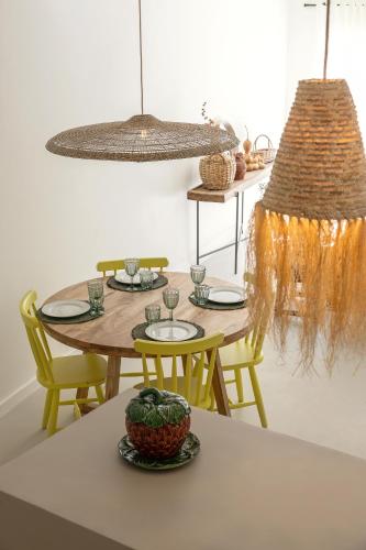 a dining room with a table with yellow chairs at Casa da Rosalina in Marvão