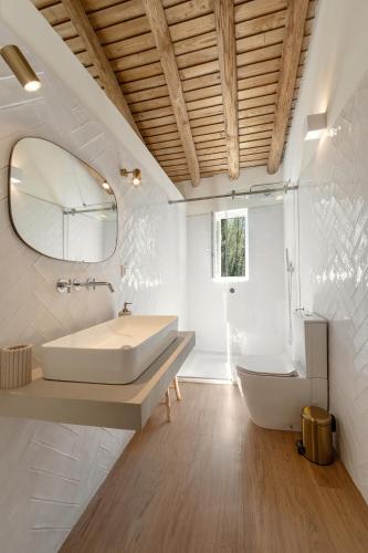 a bathroom with a tub and a sink and a mirror at Casa da Rosalina in Marvão
