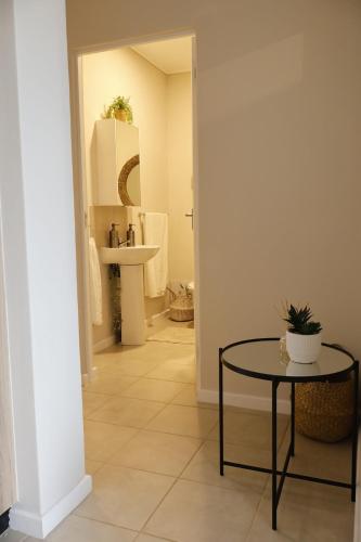 a hallway with a table and a bathroom at Charming 2 Bedroom apartment in Ballito