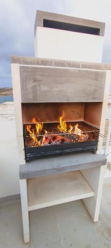 a fireplace on a beach with flames in it at Charming Townhouse - Steps from Waterfront in Marsaxlokk