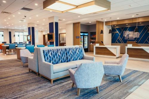 a waiting room with chairs and a couch and tables at Holiday Inn Express - Des Moines - Ankeny by IHG in Ankeny