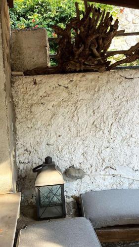 a lamp sitting next to a wall with a bench at Petriya Kontias in Kondiás