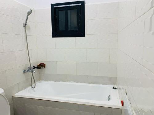 a bath tub in a bathroom with a window at Krysta Light Guest House in Kribi