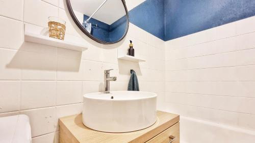 une salle de bain avec un lavabo blanc et un miroir dans l'établissement Cocon Design & Confortable - Parking - RBNB, à Colmar