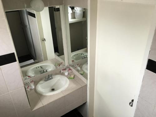 a bathroom with three sinks and a mirror at Hotel Del Sol Inn in Rosarito