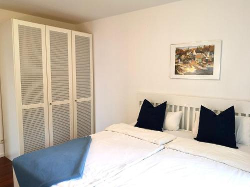 a bedroom with a large white bed with blue pillows at Bodensee Bungalow in Immenstaad am Bodensee
