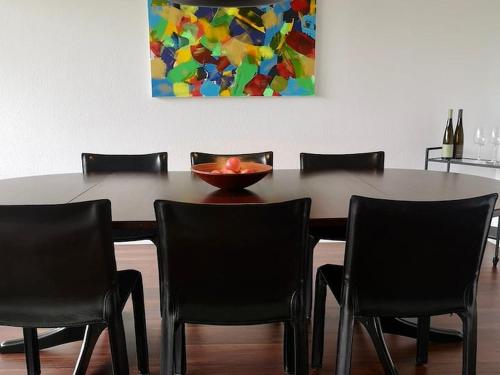 a dining room table with chairs and a bowl on it at Bodensee Bungalow in Immenstaad am Bodensee