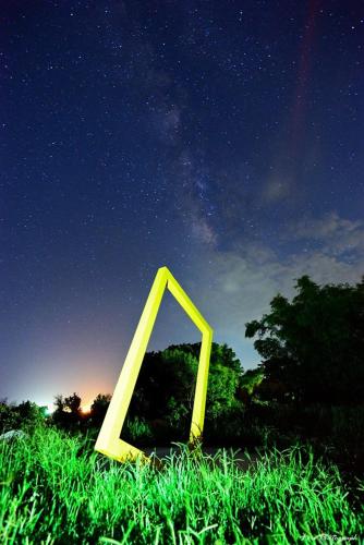 a yellow triangle sitting in the grass at night at 三仙台星辰民宿 in Chenggong