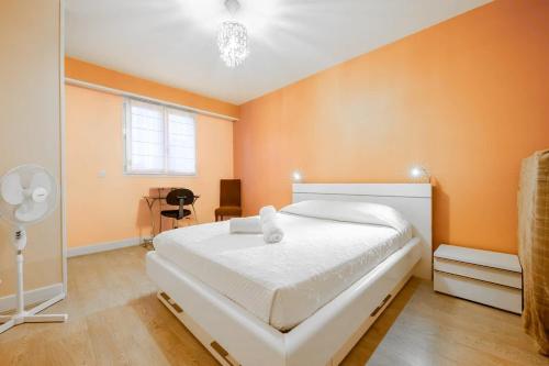 une chambre avec un grand lit aux murs orange dans l'établissement La Rochelle en famille - 5 personnes, à La Rochelle