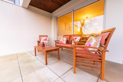 une véranda avec deux bancs et une table dans l'établissement La Rochelle en famille - 5 personnes, à La Rochelle