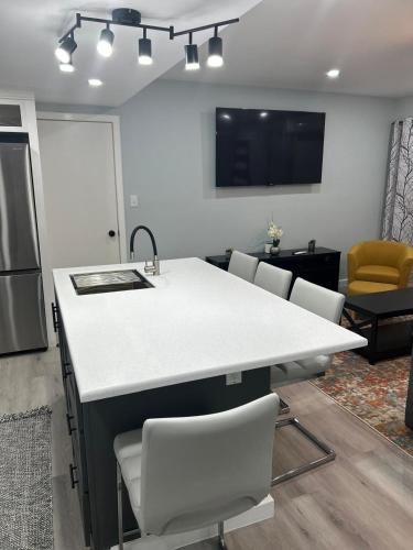 a kitchen with a sink and a counter with chairs at Xoop Homes - Zinnia #2 in Osbourn