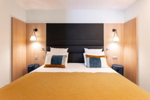 a bedroom with a large bed with two pillows at Mercure Grenoble Centre Porte des Alpes in Grenoble