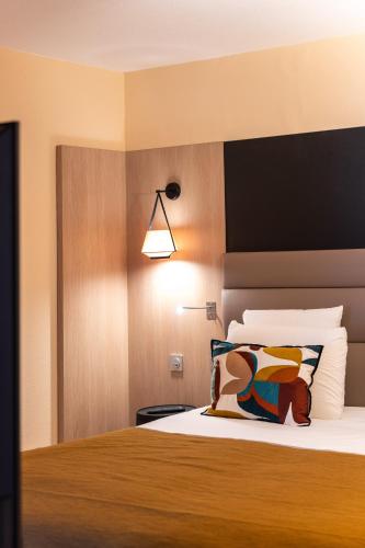 a bedroom with a bed with a black headboard at Mercure Grenoble Centre Porte des Alpes in Grenoble