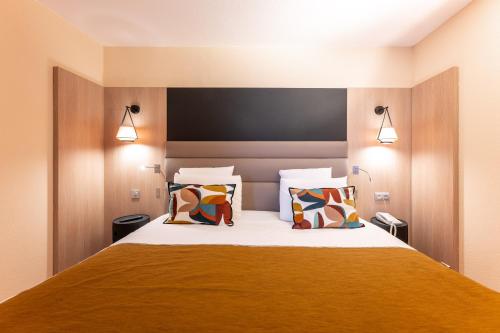 a bedroom with a large bed with two pillows at Mercure Grenoble Centre Porte des Alpes in Grenoble