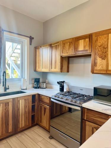 a kitchen with wooden cabinets and a stove top oven at Quiet Condo-Half Moon Bay Beach in West End
