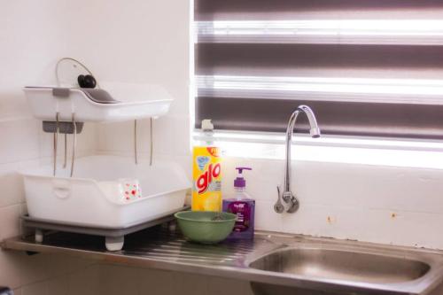 a kitchen counter with a sink next to a window at Hana Homestay in Tawau