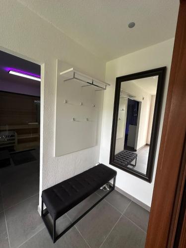 a black bench in a room with a mirror at Ferienwohnung mit Pool und Sauna - Medebach in Medebach