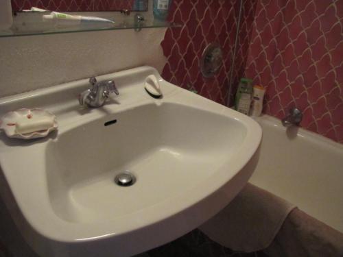 La salle de bains est pourvue d'un lavabo blanc et d'une baignoire. dans l'établissement Coquillages et Crustacés - Piscine & Tennis, à Gassin