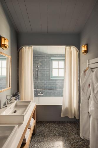 une salle de bain avec une baignoire et un lavabo dans l'établissement La Mission Hôtel & SPA - l'île d'Yeu, à L'Ile d'Yeu
