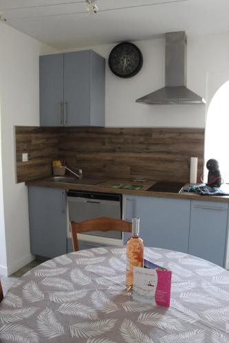 - une table dans une cuisine avec une bouteille dans l'établissement la villa des six ifs- L'olivier, à Flayosc