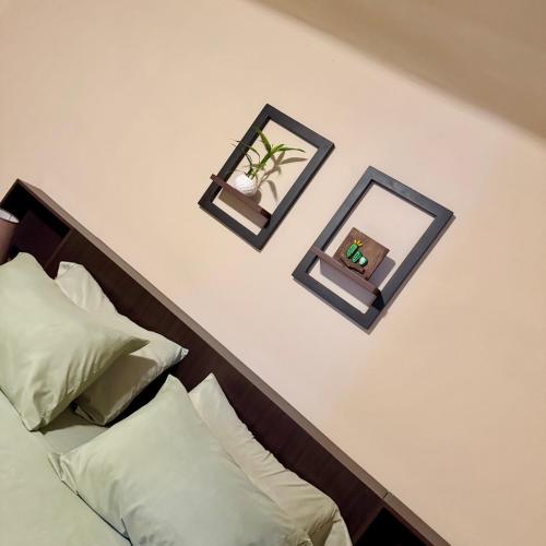 due specchi su una parete bianca sopra un letto di habitación doble, cama queen, terraza y plantas a Cochabamba