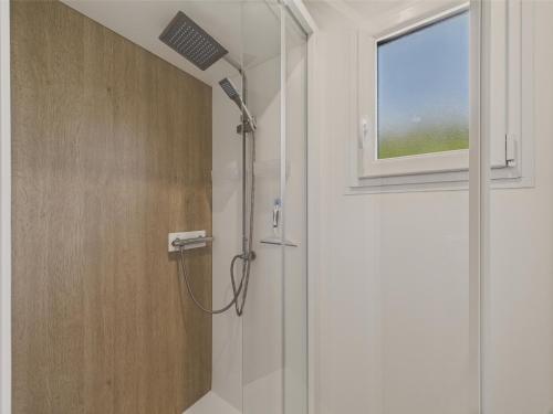 La salle de bains est pourvue d'une douche et d'une fenêtre. dans l'établissement Chalet pour 6 - Piscine chauffée - Terrasse, à Bretignolles-sur-Mer