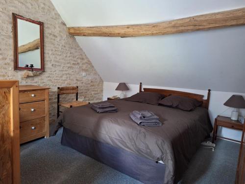 une chambre avec un lit, une commode et un miroir dans l'établissement La maison du ruisseau, à Asnières-sous-Bois