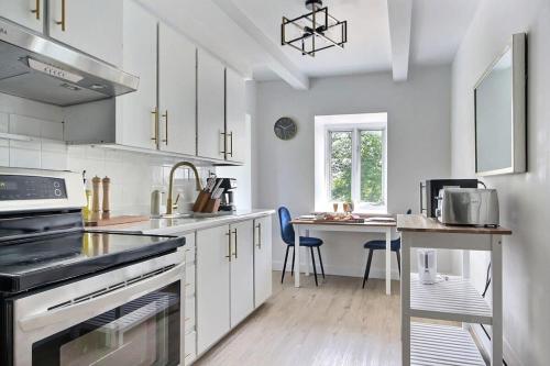 a kitchen with a sink and a stove top oven at Cozy 2BR - 2 King Beds & 2 Parking - 8min to Old Town in Quebec City