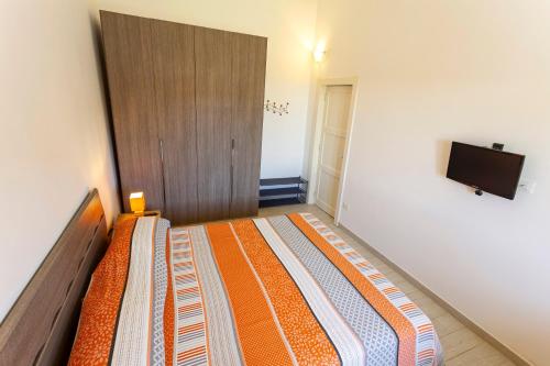a bedroom with a bed and a tv on a wall at Villanna - Villa con piscina & splendido giardino in Alimini