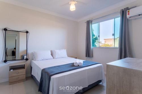 a bedroom with a bed with a mirror and a window at Apto 2 Quartos c/ Ar a 270m da Praia GPS0102 in Imbituba