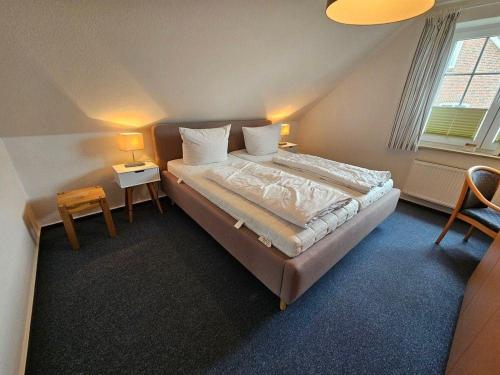 a bedroom with a large bed with two tables and two lamps at Ostseekoje-im-Haus-zwischen-den-Wassern in Behrensdorf