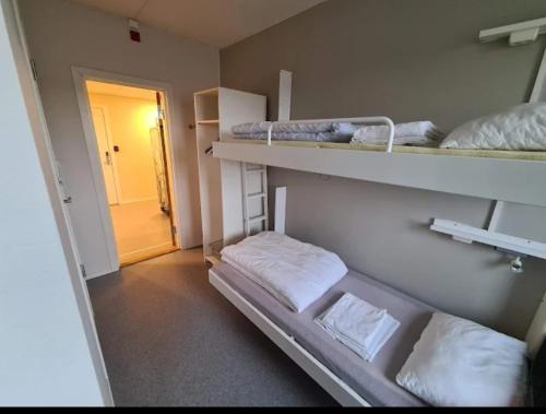 a room with two bunk beds and a hallway at Bodo Motel Norway in Bodø