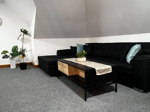 a living room with a black couch and a coffee table at Apartnám Lucy in Martin