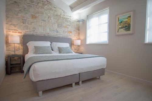 a bedroom with a large bed with a stone wall at Agromarino in Sirolo