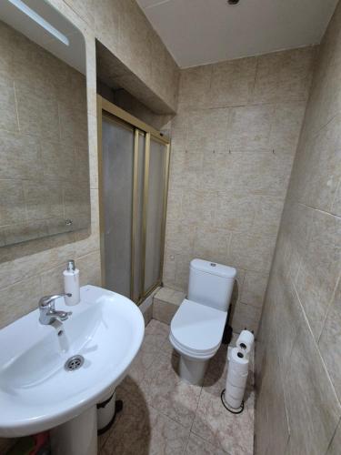 Un baño con lavabo blanco y inodoro. en Mary home, en Barcelona