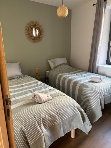 deux lits côte à côte dans une chambre dans l'établissement En si bon chemin - Gîte chemin 65, à Le Monastier sur Gazeille