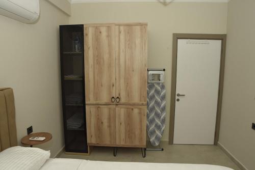 a bedroom with a wooden cabinet and a tie at Selinti City Luxury Apartment in Gazipasa
