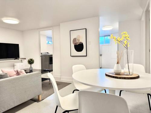 a white living room with a white table and chairs at 4 Grandes Chambres Centre-Ville in Quebec City