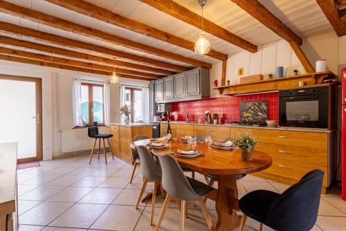 une grande cuisine avec une table et des chaises en bois dans l'établissement Le Retro pause idéale entre Genève&Annecy, à Beaumont