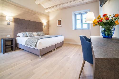 a bedroom with a bed and a vase of flowers at Agromarino in Sirolo