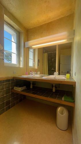 une salle de bain avec deux lavabos et un grand miroir dans l'établissement Ty Prévosto - jardin clos - plage à pieds, à Camaret-sur-Mer