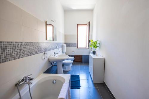 a bathroom with two toilets and a tub and a sink at Casa Cloe Mondello in Palermo
